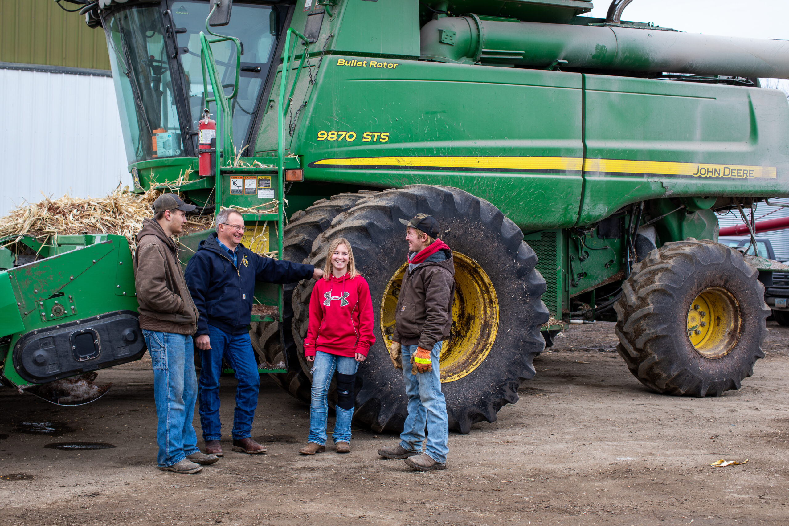 Four CHS board members standing in front of agriculture equipment