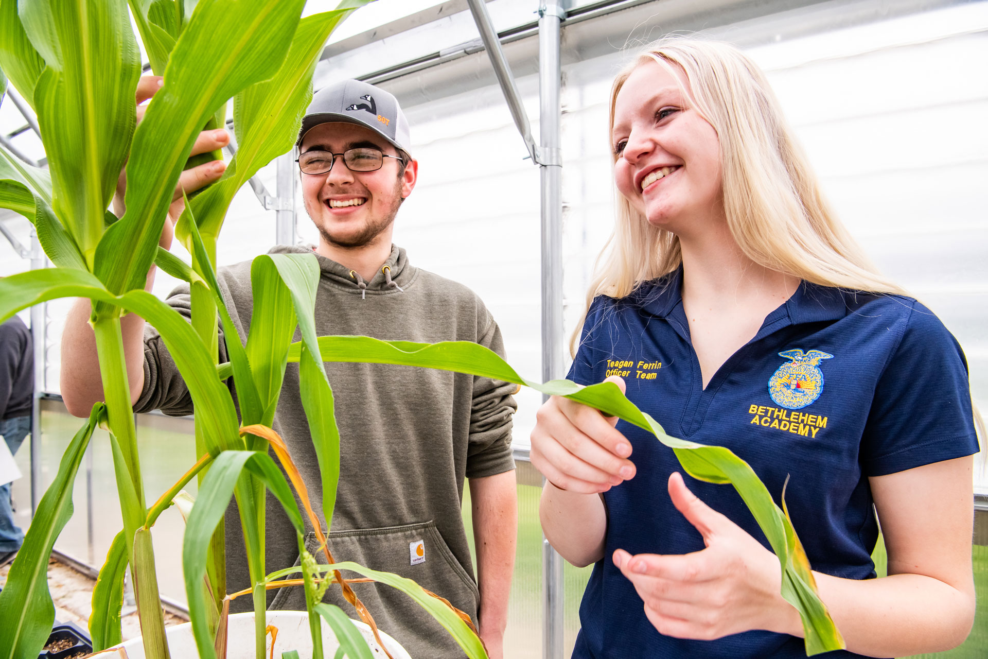 Two FFA members looking at a plant